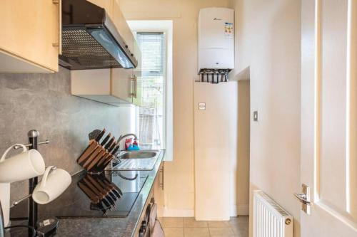 a kitchen with a stove top oven next to a window at The Summit Apartment Holburn - Lovely 1 bedroom in Aberdeen