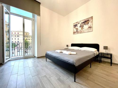 um quarto com uma cama e uma grande janela em Colosseum Guest House em Roma
