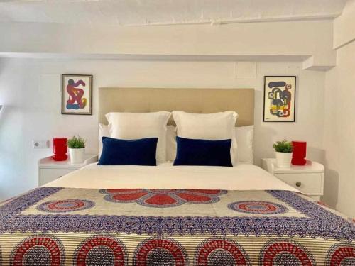 a bedroom with a large bed with blue and red pillows at Lovely Duplex in Seville
