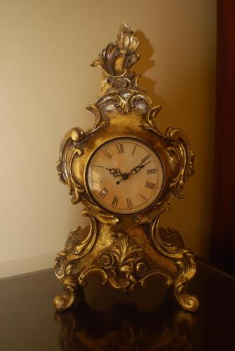 a gold clock sitting on top of a table at Clonganny House in Ballygarrett