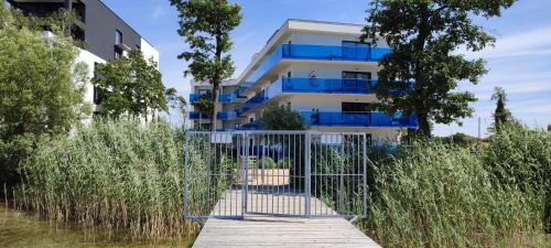a gate in front of a building with tall grass at Aquarius Holiday Boszkowo Apartamenty in Boszkowo