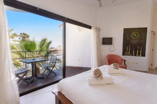 Schlafzimmer mit einem Bett und einem großen Fenster mit Aussicht in der Unterkunft 3h La Quinta - Wonderful 4 Bed Villa Wth Pool in San Miguel de Abona