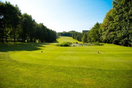 un campo de golf con un campo verde y árboles en Das Vesper, en Sprockhövel