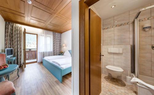 a bathroom with a bed and a toilet in a room at Heart Hotel Nordstern in Mayrhofen