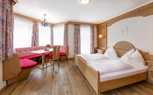 a hotel room with a bed and a table at Heart Hotel Nordstern in Mayrhofen