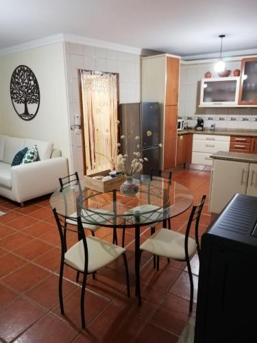 a living room with a glass table and chairs at Casinha de Nogueirinha in Macedo de Cavaleiros