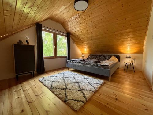 a bedroom with a bed and a wooden ceiling at Tópart Nyaraló in Sárospatak