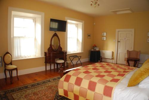 a bedroom with a bed with a checkered blanket at Clonganny House in Ballygarrett
