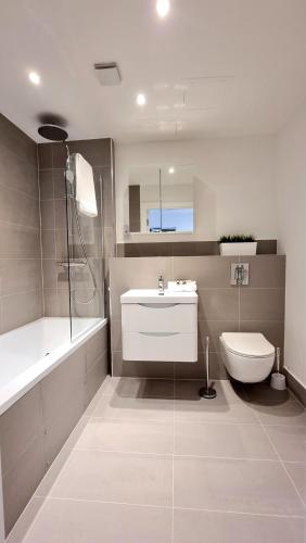 bagno con lavandino, vasca e servizi igienici di Roomspace Serviced Apartments - Kew Bridge Court a Londra