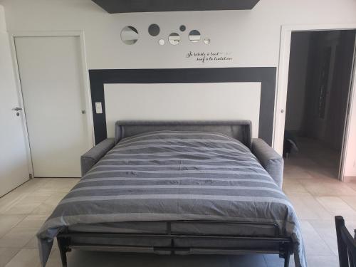 Bett in einem Schlafzimmer mit einem schwarzen und weißen Kopfteil in der Unterkunft Gîte 2-4 pers avec piscine in La Selle-sur-le-Bied