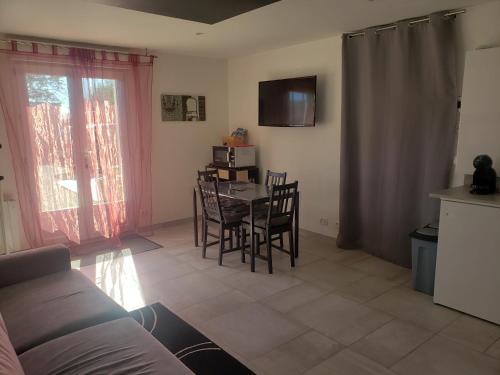 un salon avec une cuisine et une table et des chaises dans l'établissement Gîte 2-4 pers avec piscine, à La Selle-sur-le-Bied