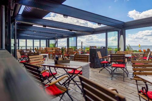 a patio with tables and chairs and a view of the ocean at Pension Café Knatter in Ueckeritz