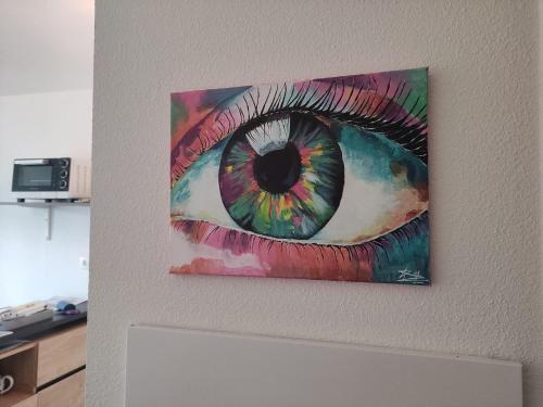 een schilderij van een oog op een muur bij Superbe appartement en rez-de-jardin à LANTON in Lanton