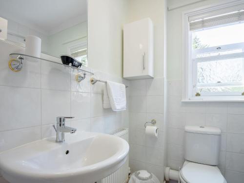 a white bathroom with a sink and a toilet at Eves Retreat in Wragby