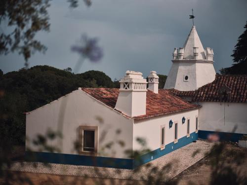 a white church with a steeple on top of it at Quinta Dos Anjos in Santarém