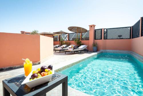 a bowl of fruit on a table next to a swimming pool at Riad 64 Maison D'hôtes & Spa in Marrakesh