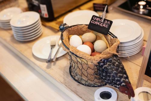 a basket of eggs on a counter with plates at Guadalupe Tuscany Resort in Braccagni