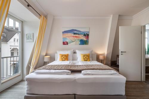 a bedroom with a large white bed in a room at FeWo Valencia Am Rosenhof - 5 Sterne DTV in Kühlungsborn