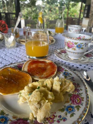 a table with a plate of food and a glass of orange juice at Roça Vale dos Prazeres in São Tomé
