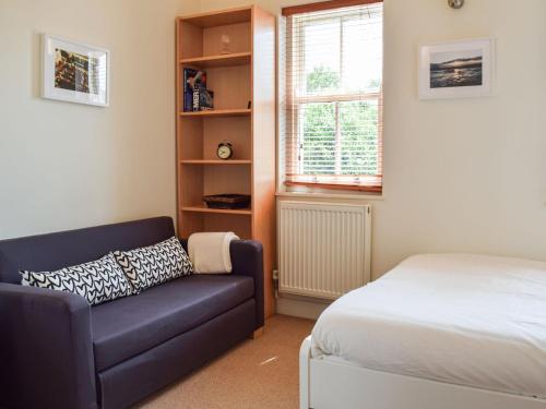 a bedroom with a couch and a bed and a window at The Pad in Lillington