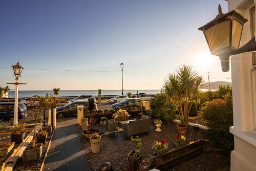 a parking lot with potted plants and the beach at Promenâd Bed & Breakfast in Llandudno