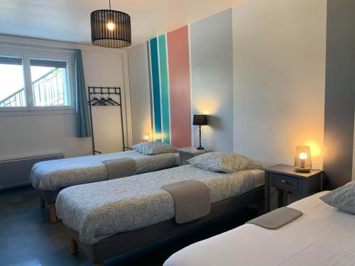a room with three beds with a rainbow on the wall at La Dame de cœur 05 in Antonaves