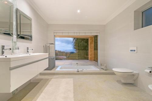 y baño con bañera, lavabo y aseo. en Lyons Den - No Load Shedding, en Ciudad del Cabo