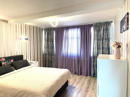 1 dormitorio con 1 cama y una ventana con cortinas moradas en Ferienwohnung Appartamento Da Vinci, en Eisenach