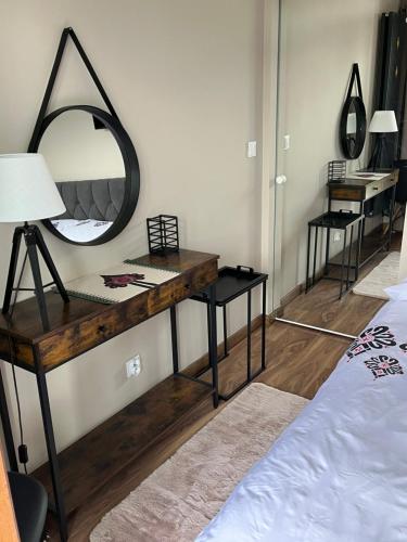 a bedroom with a desk with a mirror and a bed at Apartament Cud Miód in Kościelisko
