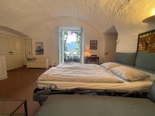ein großes Bett in einem Zimmer mit Fenster in der Unterkunft Villa Gina App 6060 in Brissago