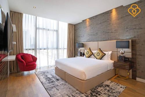 sypialnia z dużym łóżkiem i czerwonym krzesłem w obiekcie Keysplease 2 BR minutes to Dubai Mall 408, City Walk w Dubaju