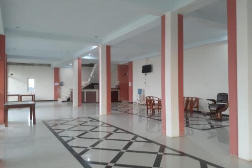 a large room with chairs and a table and a floor at EXPRESS O 91662 Kost Rumah Kaca in Mirue