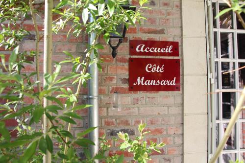 a red sign on the side of a brick building at Les Jardins Carnot in Compiègne