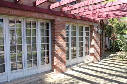 une maison en briques avec des fenêtres blanches et un mur en briques dans l'établissement Les Jardins Carnot, à Compiègne