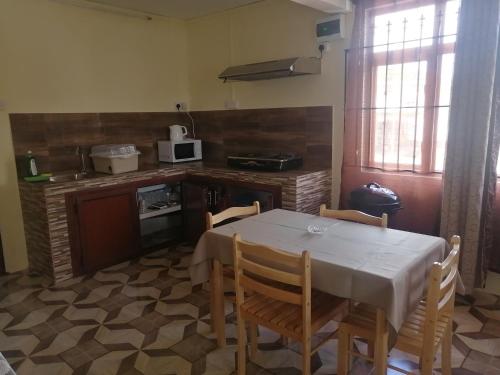 eine Küche mit einem Tisch und Stühlen im Zimmer in der Unterkunft Hortensia in Quatre Bornes