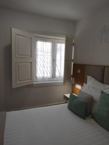 a bedroom with a bed and a window at Alojamento da Vila in Valença