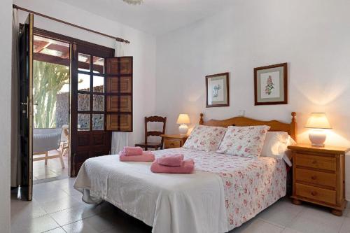 a bedroom with a bed with pink towels on it at Villa Las Palmeras in Playa Blanca