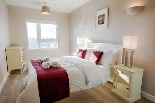 a bedroom with a white bed with towels on it at Roomspace Serviced Apartments - Vertex House in Croydon