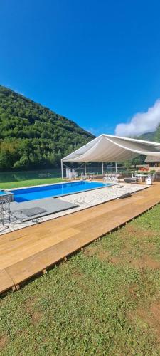 a large swimming pool with a white canopy and a table at Villa California in Rezine