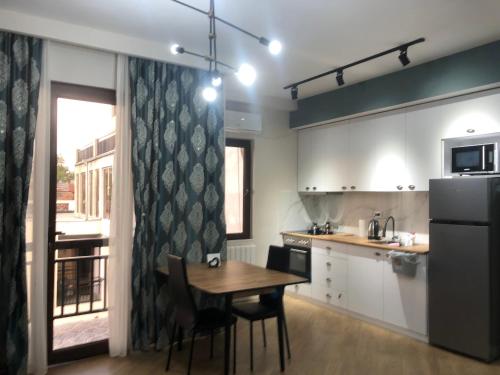 Una cocina con mesa y sillas y un refrigerador. en central square, en Kutaisi