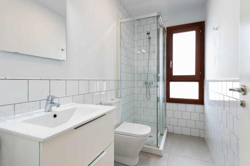 a white bathroom with a sink and a toilet at Vegueta Luxury Apartments in Las Palmas de Gran Canaria