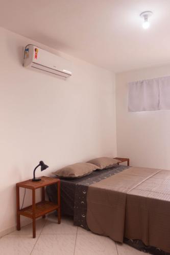 a bedroom with a bed and a lamp on a table at Casa do Pepe in Cayru
