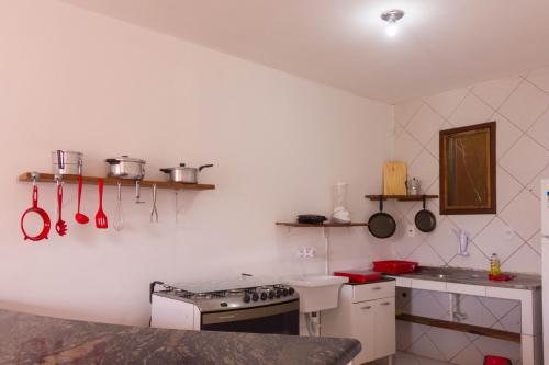 uma cozinha com fogão e um balcão com utensílios em Casa do Pepe em Cairu