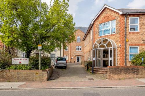 a brick building with a car parked in front of it at Roomspace Serviced Apartments - Swan House in Leatherhead