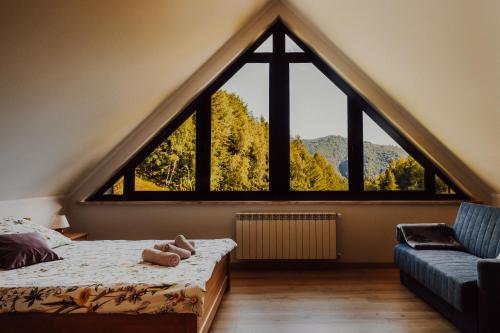 a bedroom with a large window in a loft at Apartament pod Lubaniem in Ochotnica Dolna