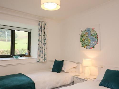 a bedroom with a bed and a window at Primrose at Stancombe Manor, Nr Kingsbridge in Kingsbridge