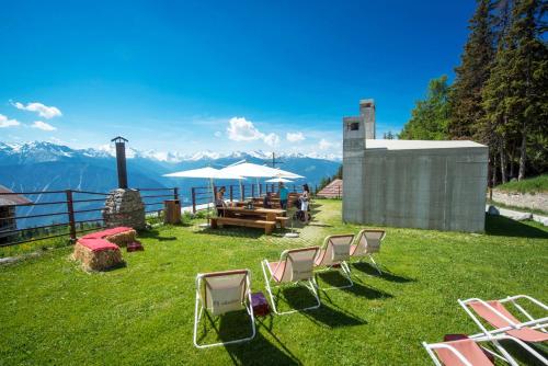a group of chairs and a table with a view of mountains at Le Mayen de Colombire in Crans-Montana