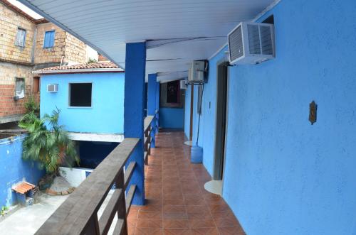 a hallway of a blue building with a balcony at Suítes good trip itacare in Itacaré