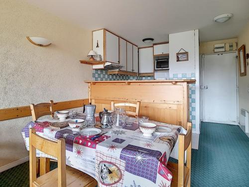 - une cuisine avec une table et de la vaisselle dans l'établissement Appartement 2 pièces · Ski aux pieds · Balcon sud · 6 pers · Centre station - FR-1-344-464, aux Menuires