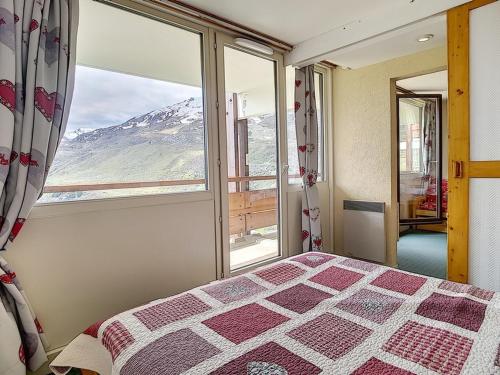 une chambre avec un lit et une vue sur une montagne dans l'établissement Appartement 2 pièces · Ski aux pieds · Balcon sud · 6 pers · Centre station - FR-1-344-464, aux Menuires